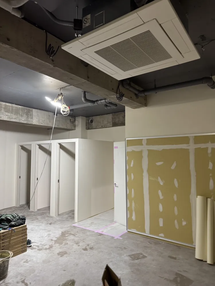 クロスを貼り終えた小部屋と、パテ処理だけ済んだ壁が同じ空間にある現場